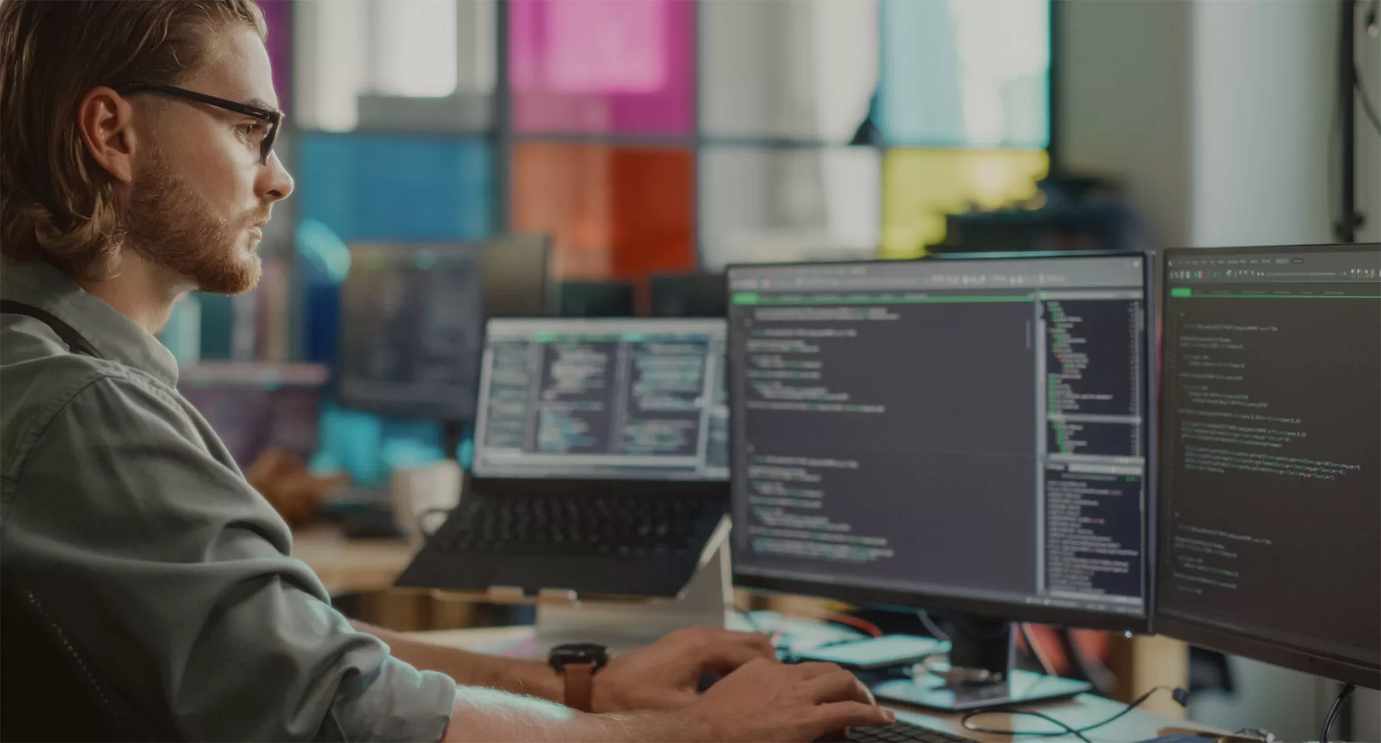 Security engineer monitoring code and system activity across multiple screens