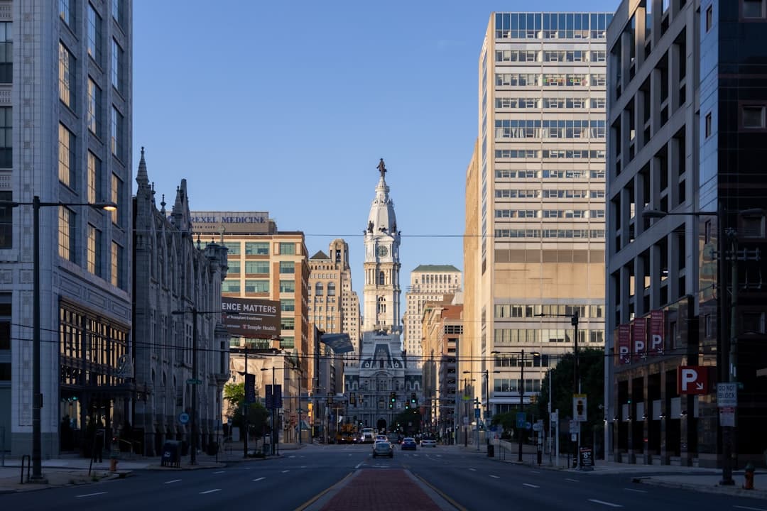 Street view towards Philadelphia City Hall with the William Penn statue atop its clock tower.